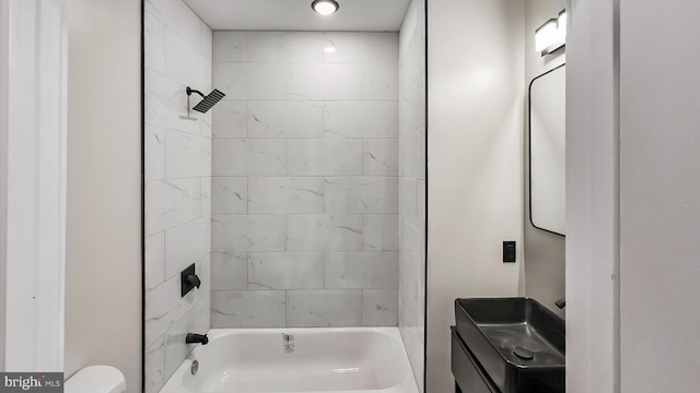 bathroom with toilet and tiled shower / bath