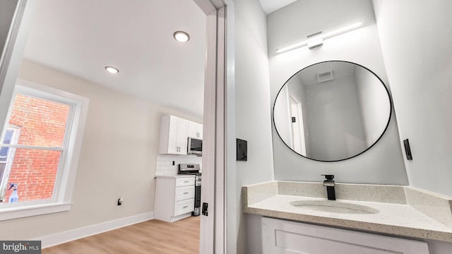 bathroom featuring tasteful backsplash, vanity, and hardwood / wood-style floors