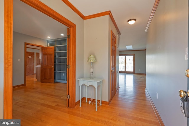 hallway with french doors, light hardwood / wood-style flooring, built in features, and ornamental molding