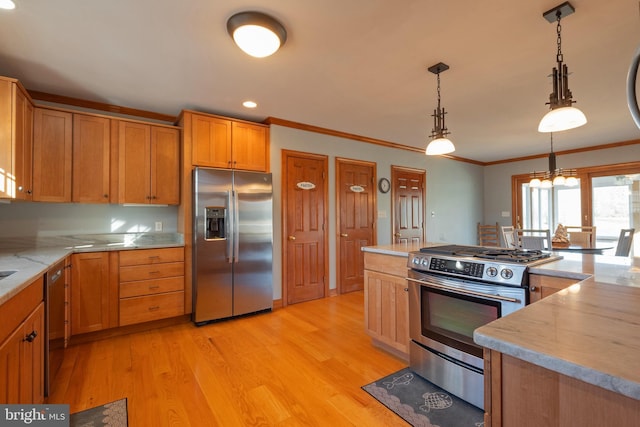 kitchen featuring light wood-type flooring, ornamental molding, stainless steel appliances, a notable chandelier, and hanging light fixtures