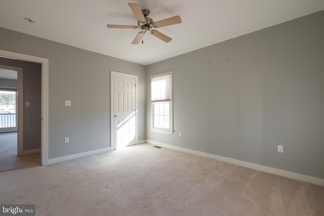 carpeted spare room featuring ceiling fan