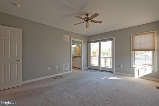 spare room with ceiling fan and light colored carpet