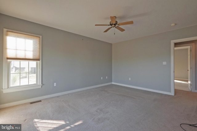 carpeted empty room featuring ceiling fan