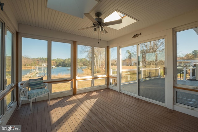 sunroom / solarium featuring a healthy amount of sunlight, a water view, and a skylight