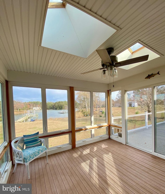 unfurnished sunroom featuring a water view, plenty of natural light, a skylight, and ceiling fan