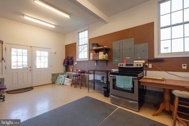 interior space with beamed ceiling, stainless steel electric range, electric panel, and concrete floors