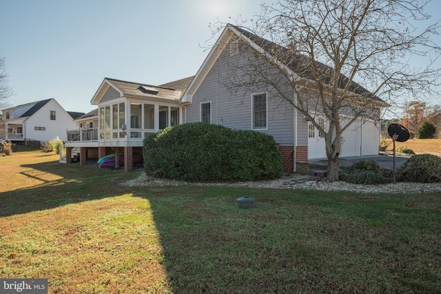 view of side of property featuring a sunroom, a garage, and a lawn