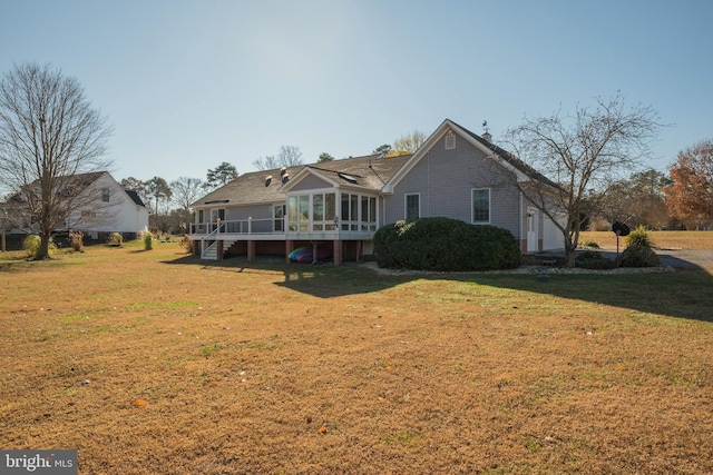 back of house featuring a yard, a wooden deck, and a sunroom