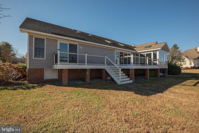 back of property featuring a sunroom, a yard, and a deck