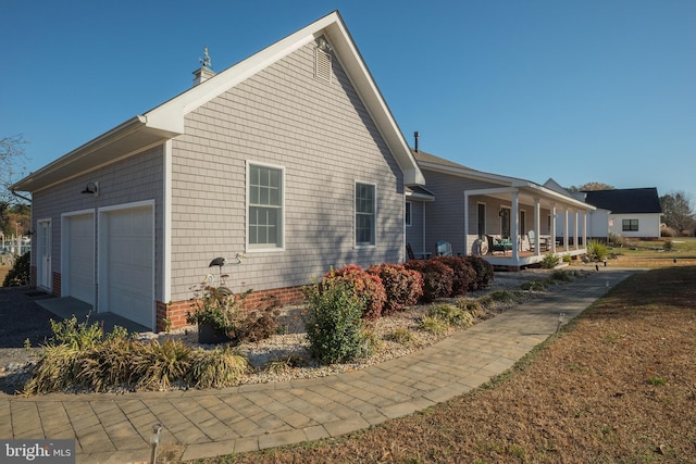 view of home's exterior with a porch and a garage