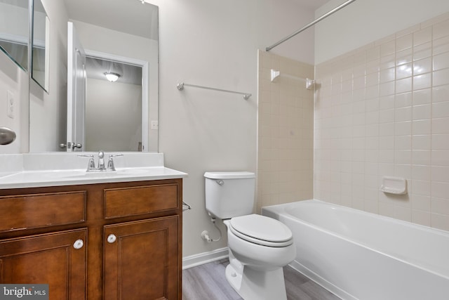 full bathroom with tiled shower / bath, hardwood / wood-style floors, vanity, and toilet