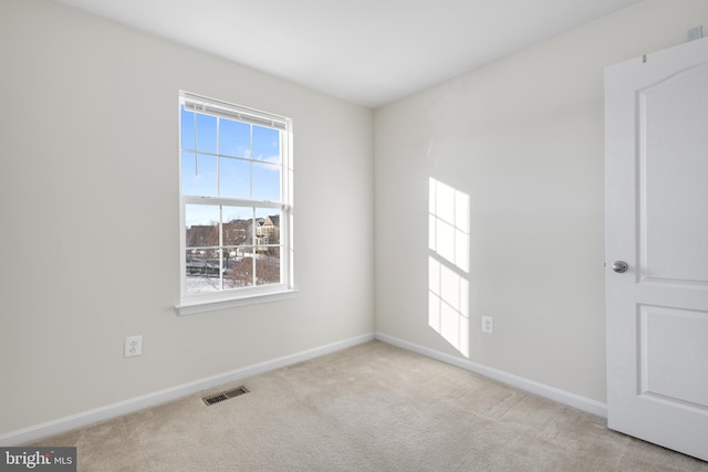 spare room featuring light colored carpet