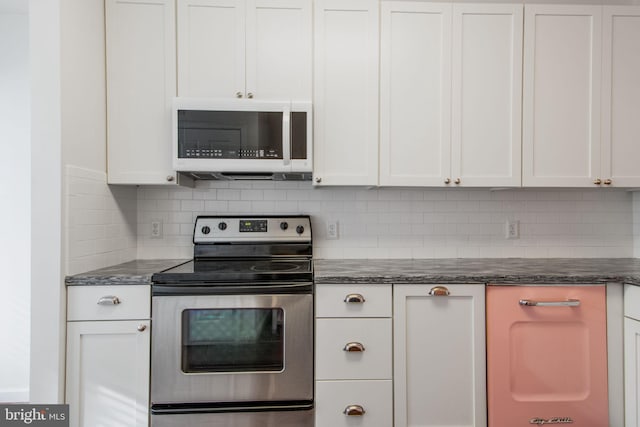 kitchen featuring stainless steel range with electric stovetop, dark stone countertops, white cabinetry, and backsplash