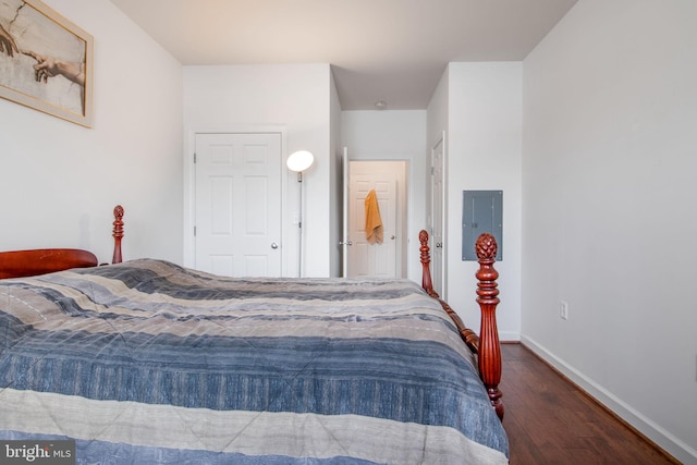 bedroom with electric panel and dark hardwood / wood-style floors