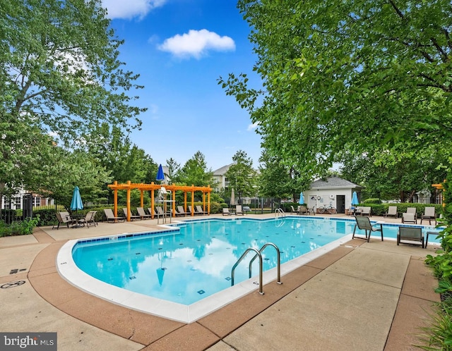 view of swimming pool with a pergola, a patio, and an outdoor structure