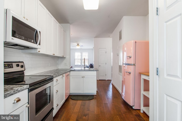 kitchen featuring kitchen peninsula, white appliances, ceiling fan, dark hardwood / wood-style floors, and white cabinetry