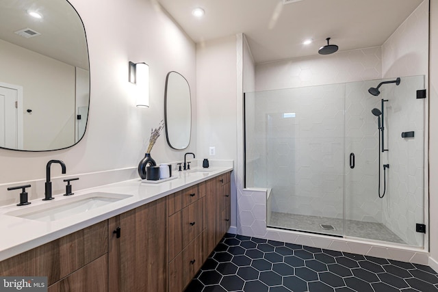 bathroom featuring a shower with shower door, vanity, and tile patterned flooring