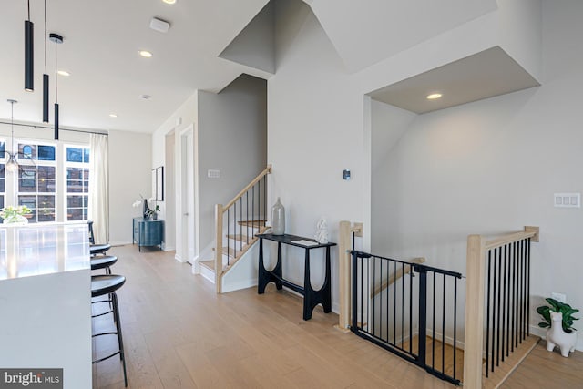 corridor featuring vaulted ceiling and light wood-type flooring