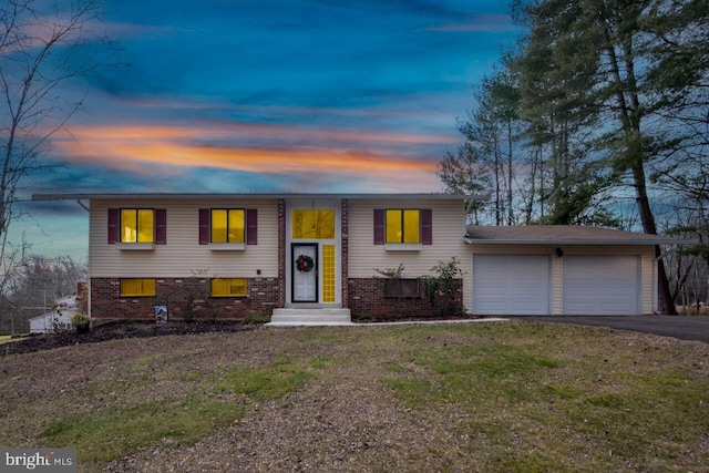 bi-level home with a yard and a garage