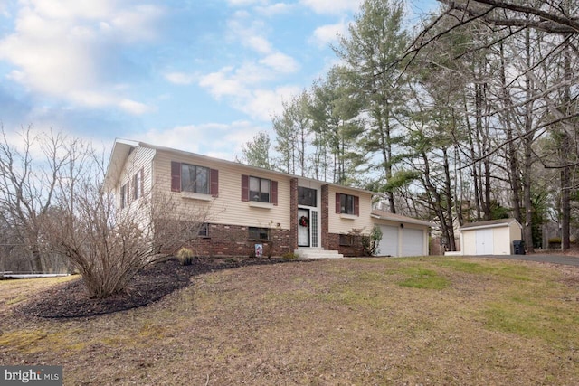 split foyer home featuring a garage, a front yard, and a storage shed