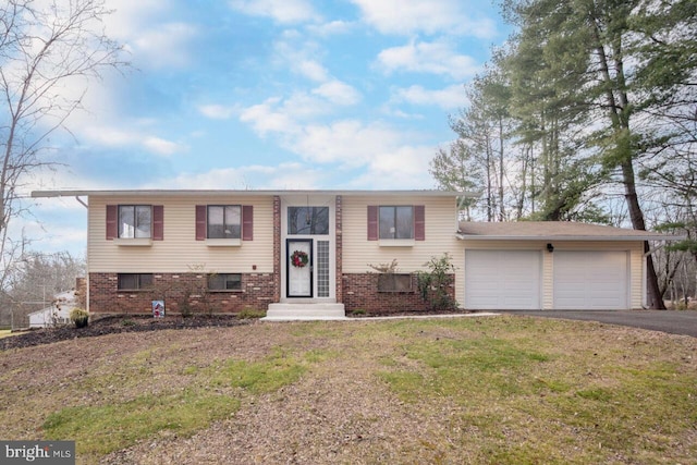 split foyer home with a garage and a front lawn