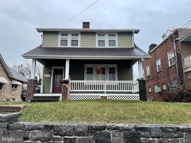 view of front of home with covered porch and a front yard