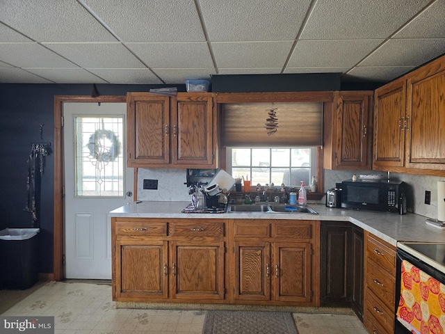 kitchen featuring a drop ceiling, electric stove, and sink