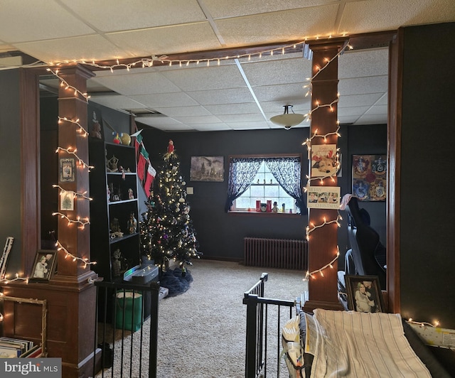 rec room featuring a paneled ceiling, radiator heating unit, and carpet