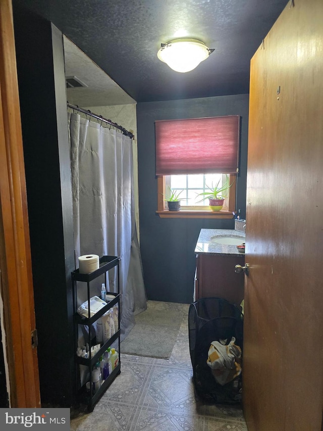 bathroom with a textured ceiling and vanity