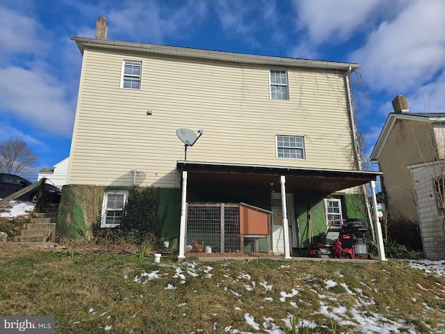 view of snow covered rear of property