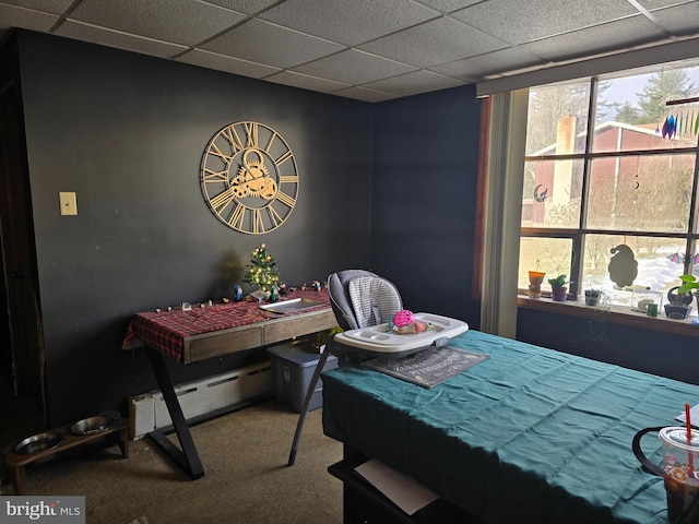 carpeted bedroom with a drop ceiling and a baseboard radiator