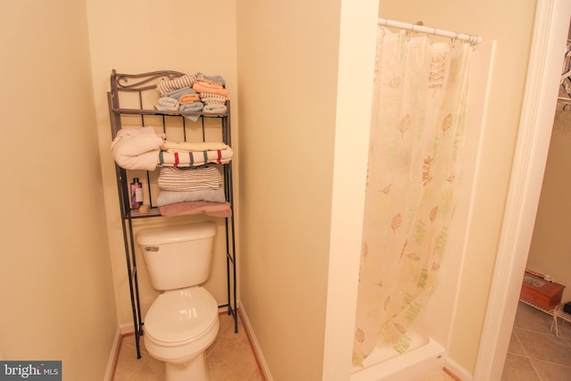 bathroom featuring tile patterned flooring, a shower with curtain, and toilet