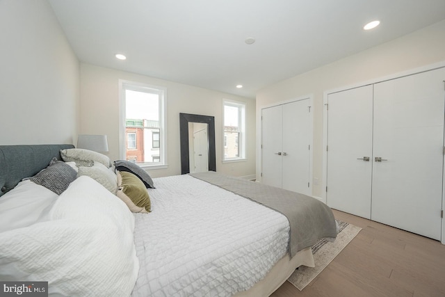 bedroom with two closets and light wood-type flooring