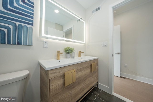 bathroom with tile patterned flooring, vanity, and toilet