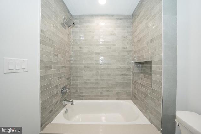 bathroom with tiled shower / bath and toilet