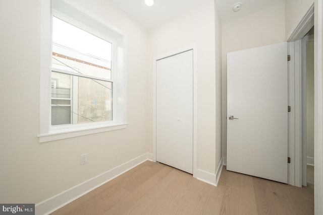 unfurnished bedroom featuring a closet and light hardwood / wood-style floors