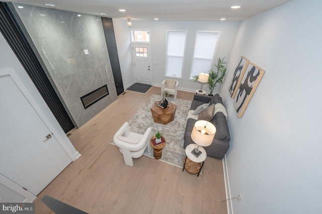 living room with a tile fireplace and light hardwood / wood-style flooring