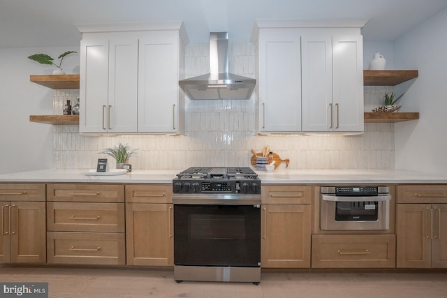 kitchen featuring white cabinets, wall chimney range hood, and stainless steel appliances