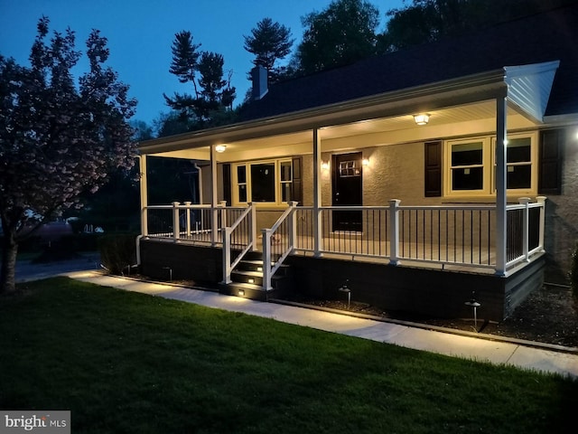 view of front of property featuring covered porch and a front lawn