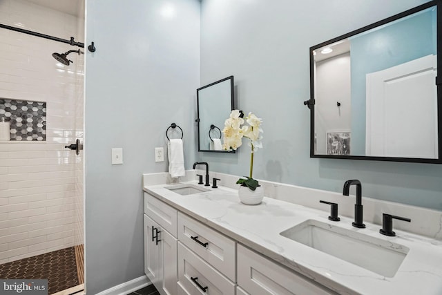 bathroom featuring a tile shower and vanity