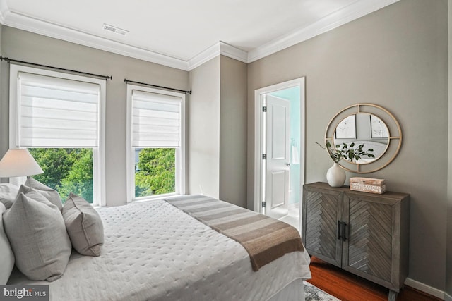 bedroom featuring connected bathroom, crown molding, and dark hardwood / wood-style floors