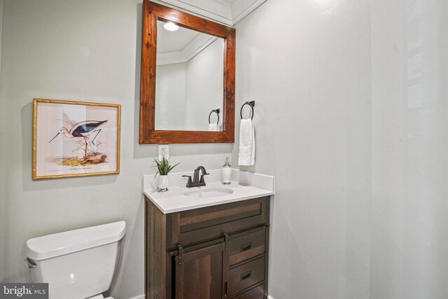 bathroom featuring vanity, ornamental molding, and toilet