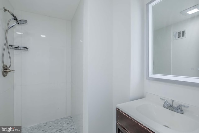 bathroom featuring vanity and tiled shower