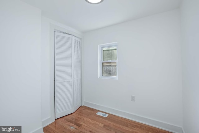 unfurnished bedroom featuring light wood-type flooring and a closet