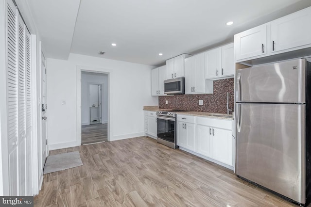 kitchen featuring white cabinets, backsplash, sink, and stainless steel appliances