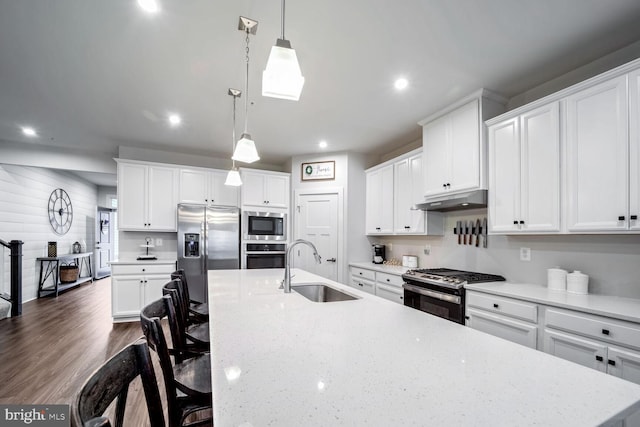 kitchen featuring sink, white cabinets, hanging light fixtures, and appliances with stainless steel finishes