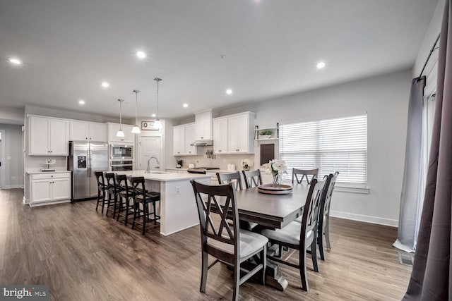 dining space with hardwood / wood-style flooring and sink