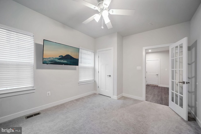 unfurnished bedroom featuring ceiling fan, light colored carpet, and french doors