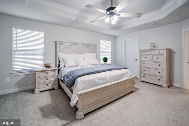 carpeted bedroom with a tray ceiling and ceiling fan