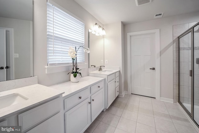 bathroom with tile patterned floors, vanity, an enclosed shower, and plenty of natural light